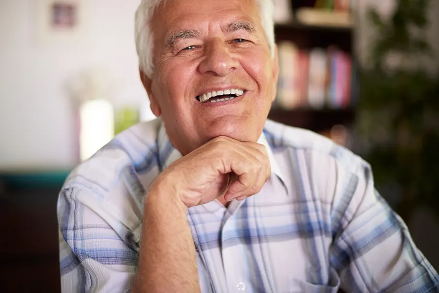 Hombre sonriendo tras implante dental